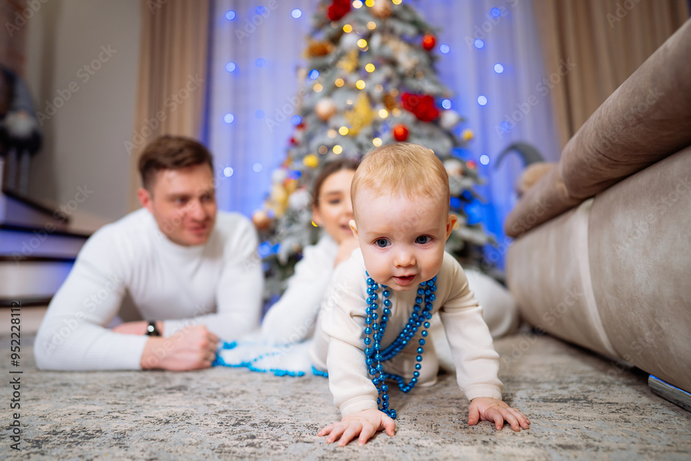 Family celebration with baby crawling near Christmas tree at home. A joyful baby in a cozy living room crawls on the carpet, surrounded by a festive atmosphere and Christmas decorations. Family celebration with baby crawling near Christmas tree at home. A joyful baby in a cozy living room crawls on the carpet, surrounded by a festive atmosphere and Christmas decorations.