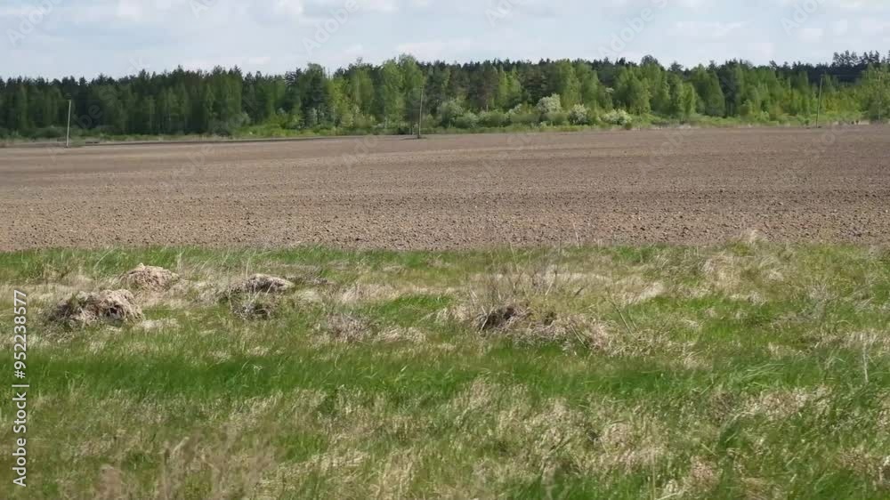 Car speeding on a road through the ploughing agricultural field. View through side window of auto in motion at plowing farmland. Tourism and travel, journey trip concept. Beautiful spring landscape. Car speeding on a road through the ploughing agricultural field. View through side window of auto in motion at plowing farmland. Tourism and travel, journey trip concept. Beautiful spring landscape.