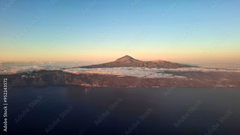 Aerial view of Tenerife island with volcano Teide in the middle with some clouds and beautiful evening light, Canary Islands, Spain Aerial view of Tenerife island with volcano Teide in the middle with some clouds and beautiful evening light, Canary Islands, Spain