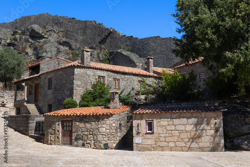 historic village of Sortelha, Portugal, featuring stone houses and ancient fortress walls under a bright blue sky. This charming medieval village is a perfect example of Portuguese cultural heritage. photo