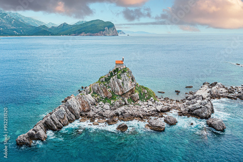 Montenegro's picturesque Petrovac coast, with its iconic islets and historic church, captured from above, offering a stunning panorama for tourists and travelers. photo