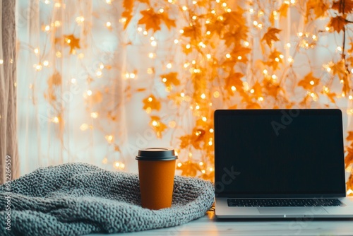 Cozy workspace with a laptop, warm coffee, and autumn decor, perfect for fall productivity and inspiration. photo