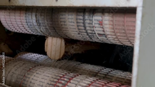 Logs moving from cutting machine at woodworking plant cut in wood boards. Timber processing and woodworking industry. Working process sawing wood boards on saw-mill factory in cut workshop.