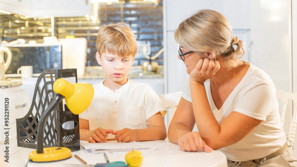 mom helps son boy do homework for school the tutor helps the child to learn mom helps son boy do homework for school the tutor helps the child to learn