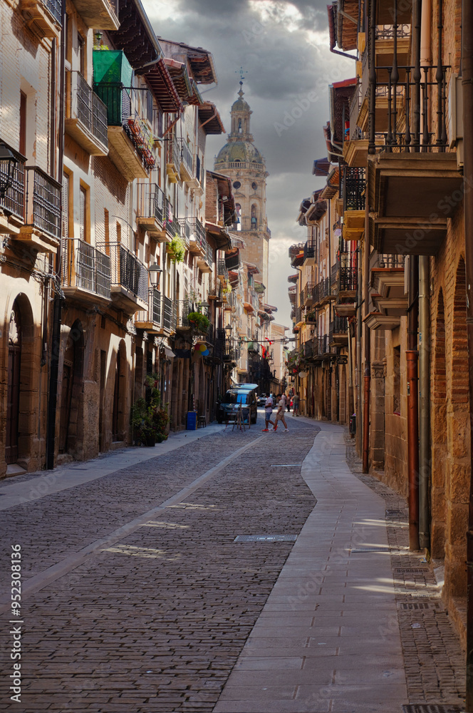 Fototapeta premium Puente de La Reina, Navarra. The tower of the church of Santiago el Mayor rises, immense, over the roofs of the town