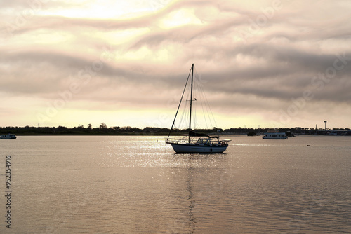 Bboat anchored on the water as the golden hues of the sunrise on the Gold Coast  photo