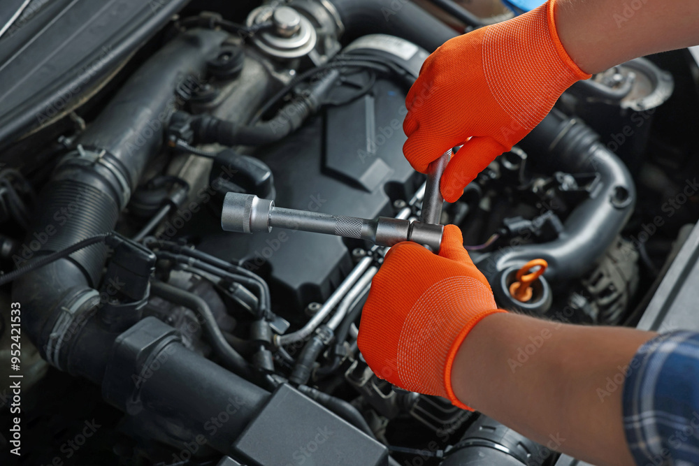 Auto mechanic with different tools fixing car at automobile repair shop, closeup Auto mechanic with different tools fixing car at automobile repair shop, closeup