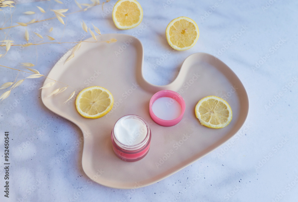 Vitamin C face cream with lemon slices on shadows background Vitamin C face cream with lemon slices on shadows background