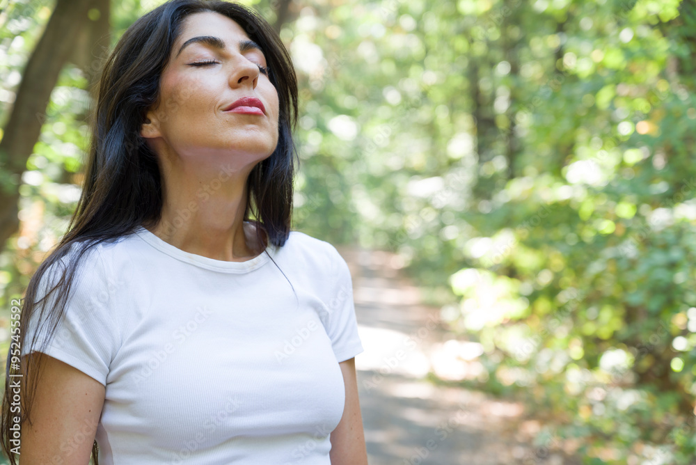 Beautiful woman relaxing and breathing fresh air with sunlight in the summer park Beautiful woman relaxing and breathing fresh air with sunlight in the summer park