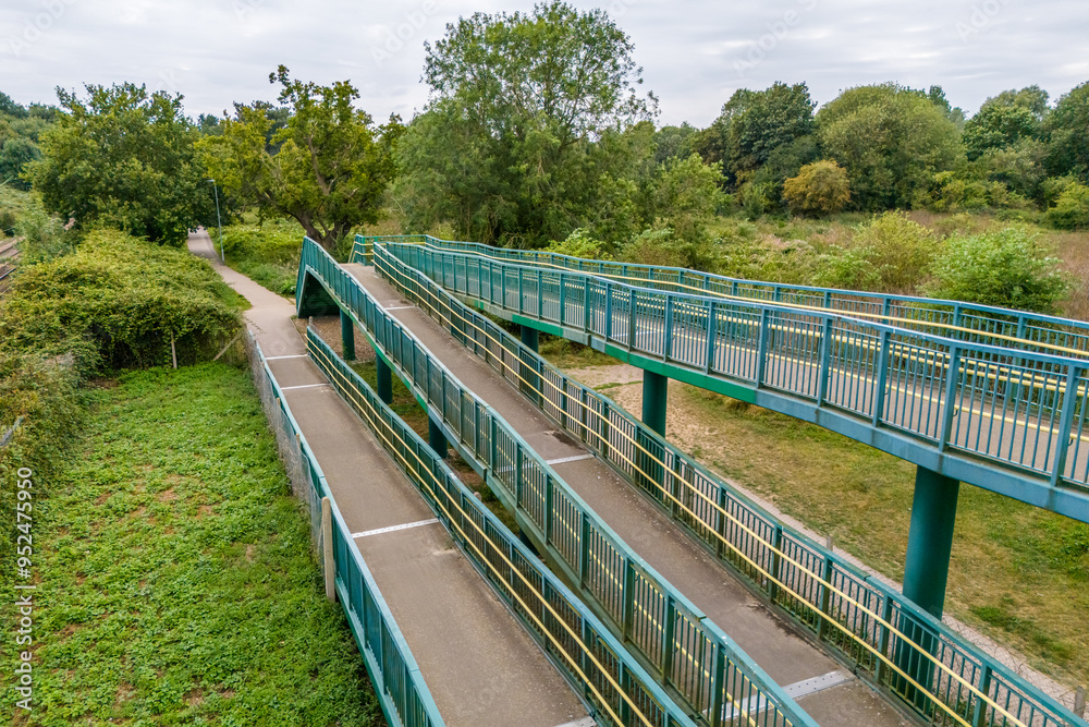 Aerial drone shot of a cyclist path for a cross bridge over the railroad