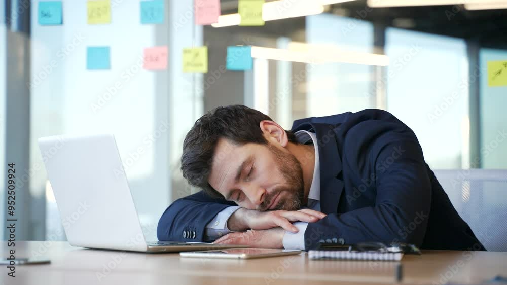 Overworked bearded businessman feels tired and wants to sleep sitting at workplace in business office. Sleepy exhausted man lay down with his head on desk, closes his eyes, dozing. Overload at work Overworked bearded businessman feels tired and wants to sleep sitting at workplace in business office. Sleepy exhausted man lay down with his head on desk, closes his eyes, dozing. Overload at work