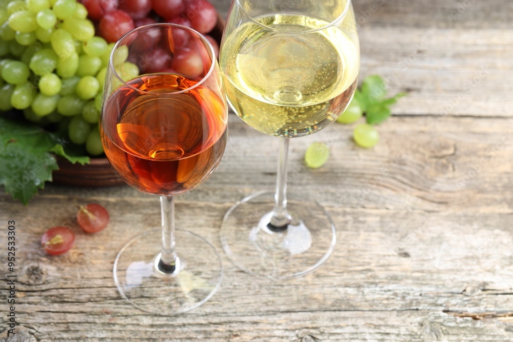 Fresh ripe grapes and glasses of wine on wooden table, closeup Fresh ripe grapes and glasses of wine on wooden table, closeup