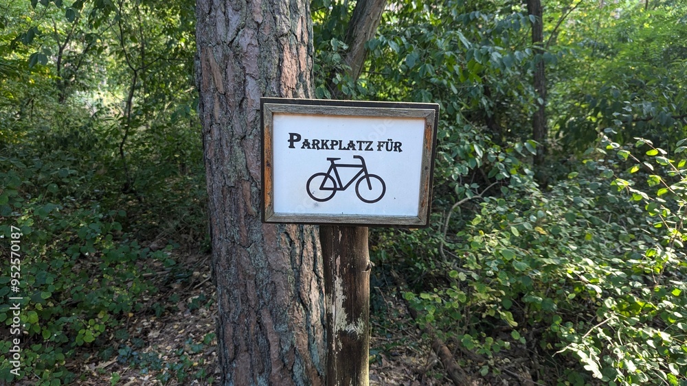 Schild mit Parkplatz für Fahrrad am Baum Schild mit Parkplatz für Fahrrad am Baum