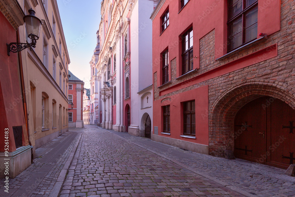 Obraz premium A deserted narrow cobblestone street in the center of Poznan at dawn.
