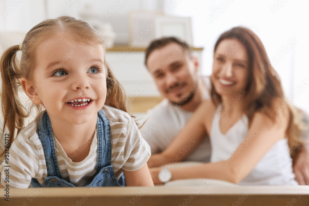 Happy family. Parents and their cute little daughter on sofa at home, selective focus Happy family. Parents and their cute little daughter on sofa at home, selective focus