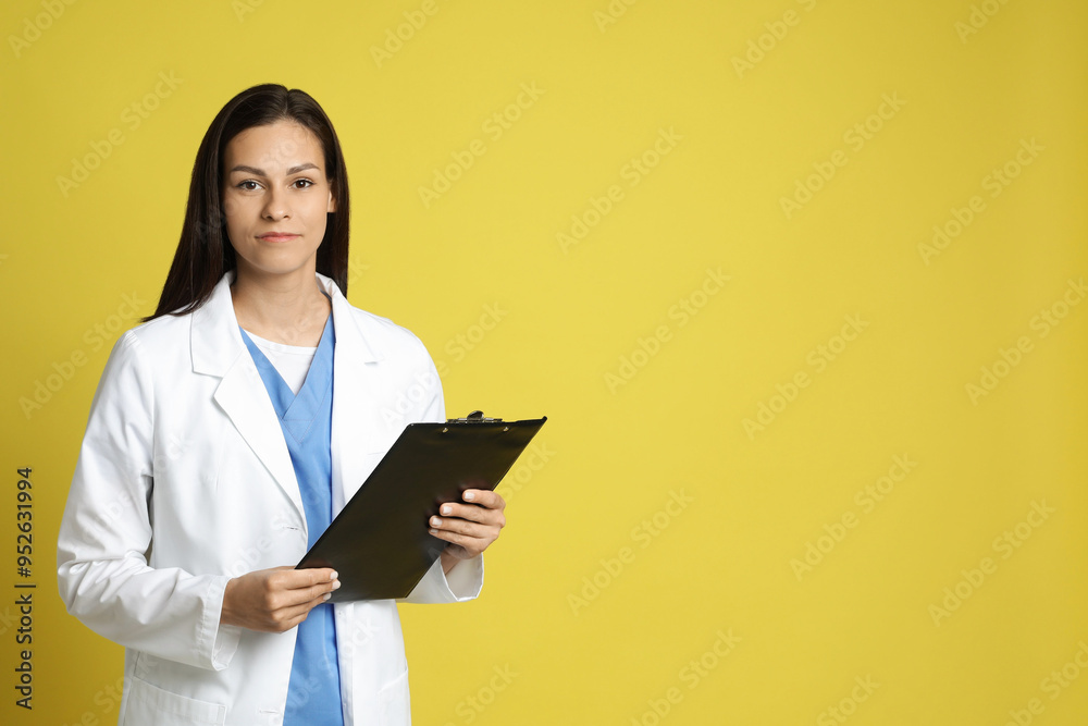 Portrait of beautiful nurse with clipboard on yellow background. Space for text Portrait of beautiful nurse with clipboard on yellow background. Space for text