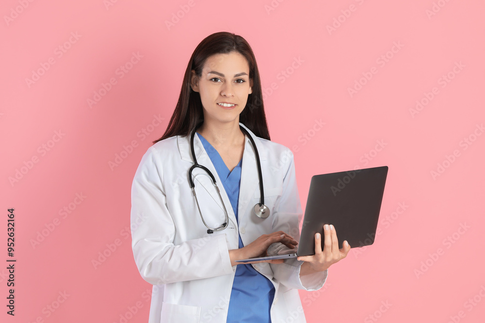Smiling nurse with laptop on pink background Smiling nurse with laptop on pink background