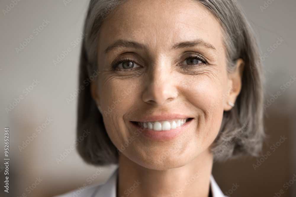 Portrait of happy beautiful middle-aged 50s woman with short haircut looking at camera, close up cropped face view on abstract background. Rejuvenating skin care products, dental clinic services ad Portrait of happy beautiful middle-aged 50s woman with short haircut looking at camera, close up cropped face view on abstract background. Rejuvenating skin care products, dental clinic services ad