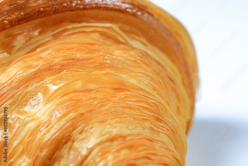 Fototapeta premium Close up, Texeture of Freshly baked croissant, Brown crispy croissants isolated on white background. French pastry closeup photo. Buttered bread croissant isolated on white background.