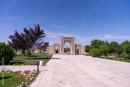 A beautiful park with a stone walkway and a large archway photo