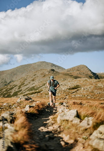 Fit young adult trail runs on ridgetop in White Mountains, NH photo