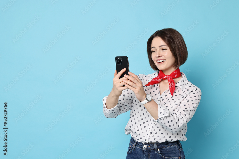 Smiling woman with smartphone on light blue background. Space for text Smiling woman with smartphone on light blue background. Space for text