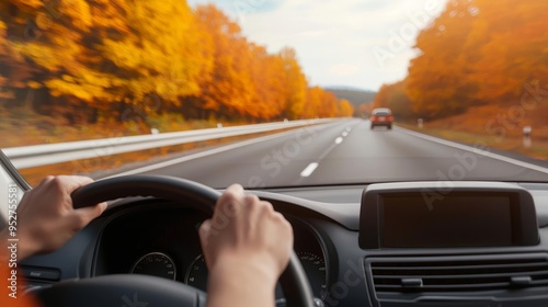 POV from inside a car on a highway, hands on the steering wheel, road ahead blurred by motion, autumn scenery photo