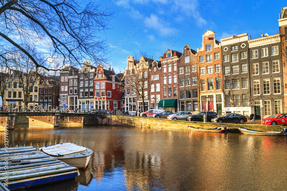 Obraz premium Cityscape on a sunny winter day - view of the water canal in the historic center of Amsterdam, the Netherlands