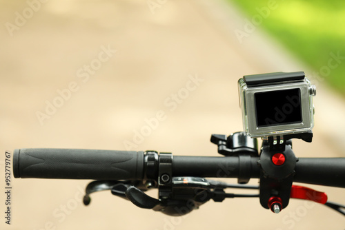 Modern action camera with mount on bicycle outdoors, closeup