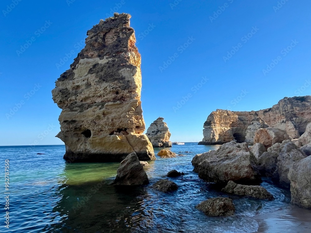 Fototapeta premium Oddly shaped jagged rock formations and cliffs at Lagoa Beach, Faro District, Southern Portugal.