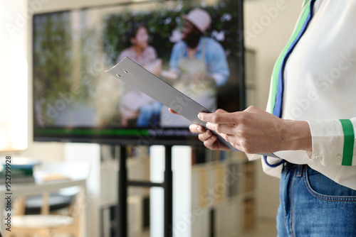 Close up background image of female teacher holding clipboard and explaining topic while working at school, copy space