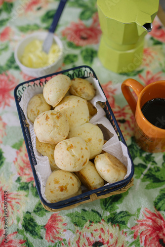 Mesa de café da manhã com pão de queijo, manteiga e café