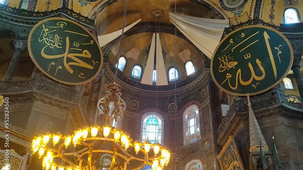 Panning shot of the interior of Hagia Sophia mosque in Istanbul, with Islamic symbols, large windows, and chandeliers. Religion, faith, and exotic travel