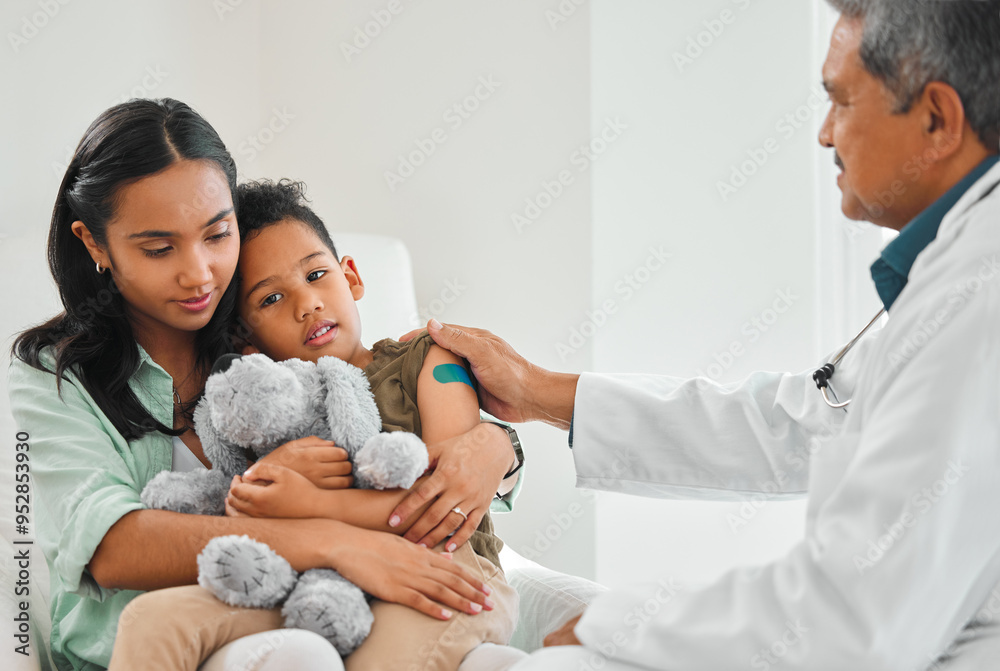 Obraz premium Doctor, woman and child with bandage plaster and vaccine for growth or development in clinic. Mother, boy and pediatrician with comfort at hospital for immunity, routine checkup or illness prevention