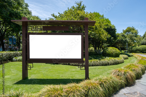 Mockup background texture of a blank white billboard with a wooden frame featuring traditional Chinese architectural elements, in a public park or garden surrounded by manicured lawns, paths and trees