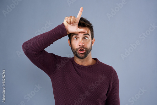 Obraz na plátne Studio, portrait and man with loser sign for feedback, opinion and wrong decision with emoji reaction