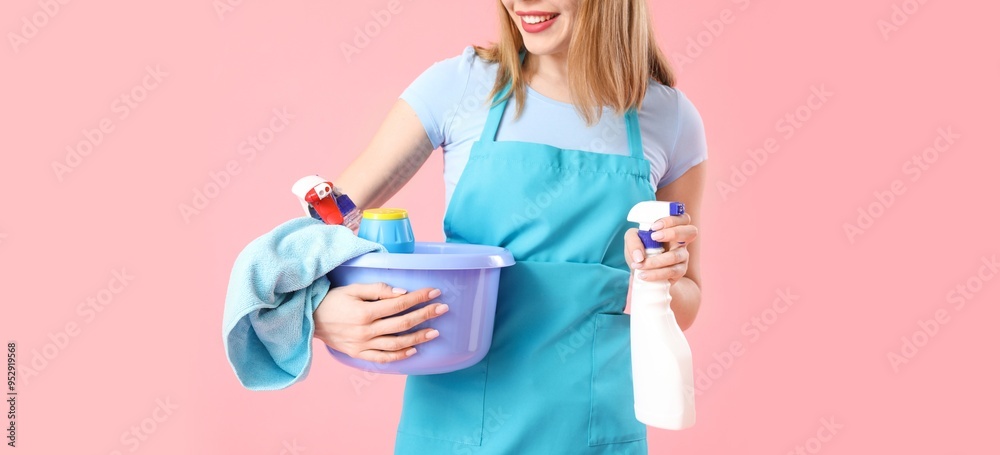 Young woman with cleaning supplies on pink background Young woman with cleaning supplies on pink background