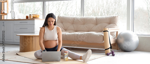 Sporty pregnant woman using...