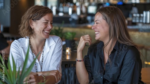 Two women chatting and laughing in a bar
