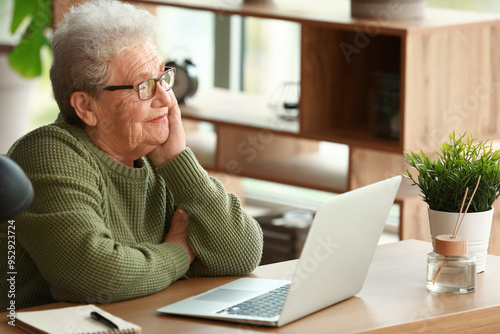 Senior woman sitting at tab...