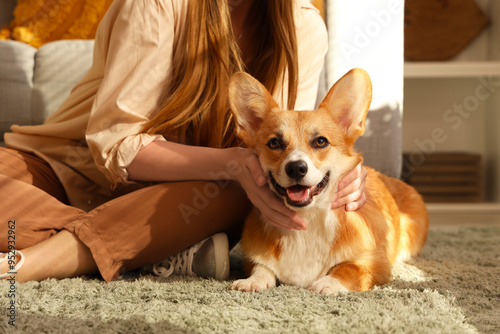 Young woman with Corgi dog at home on Thanksgiving Day, closeup photo