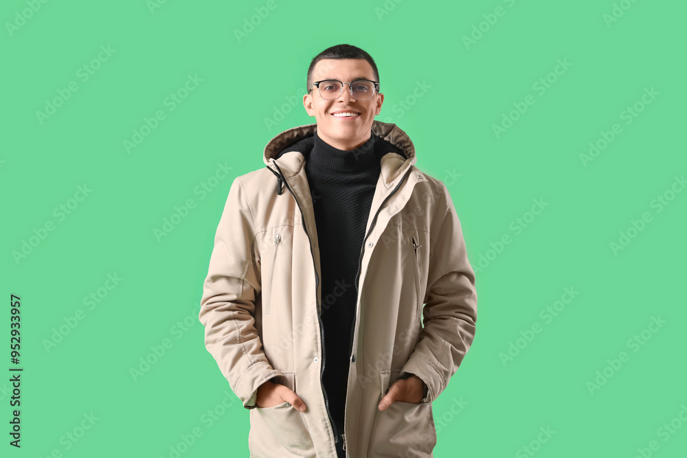 Young man in winter clothes on green background Young man in winter clothes on green background