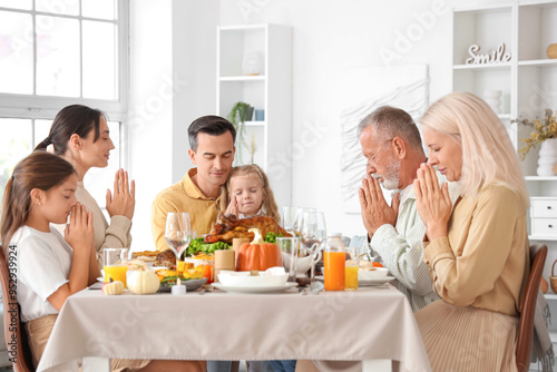 Happy family praying before...