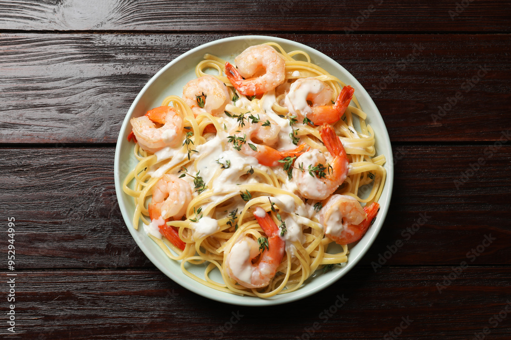 Delicious pasta with shrimps and creamy sauce on wooden table, top view Delicious pasta with shrimps and creamy sauce on wooden table, top view