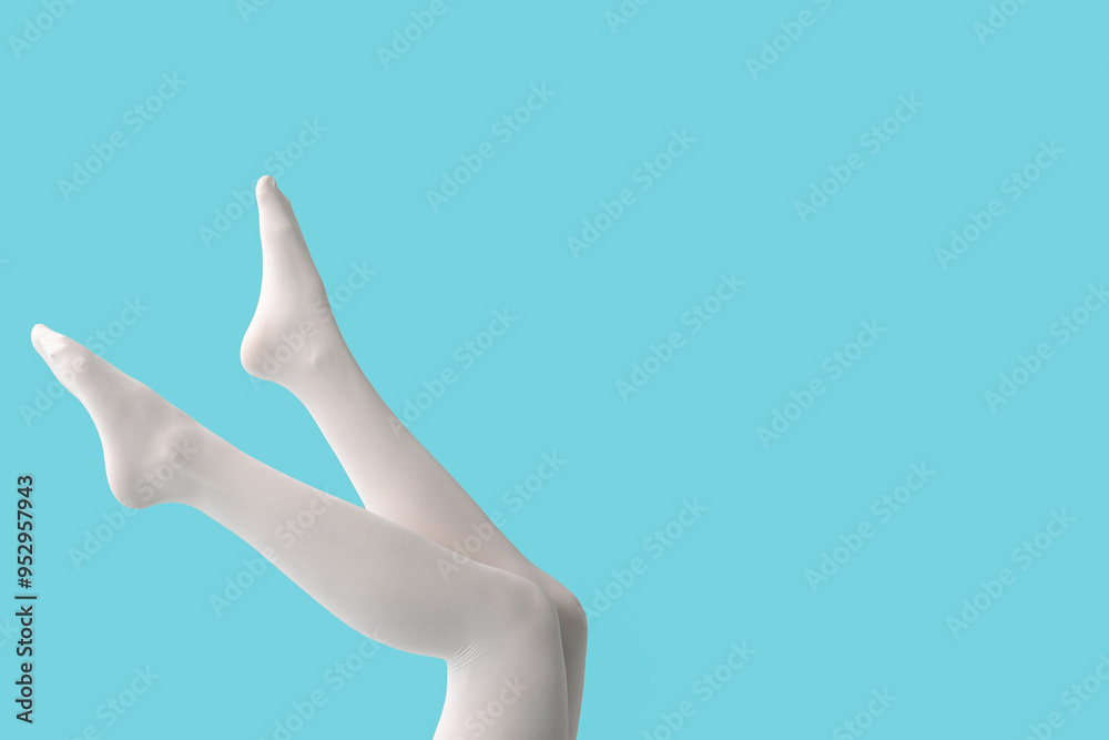 Legs of young woman in white tights on blue background Legs of young woman in white tights on blue background