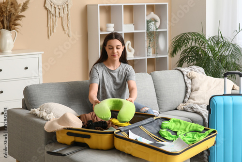 Young woman packing pillow ...