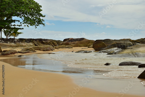 A tropical beach. Sand, rocks and the sea.
