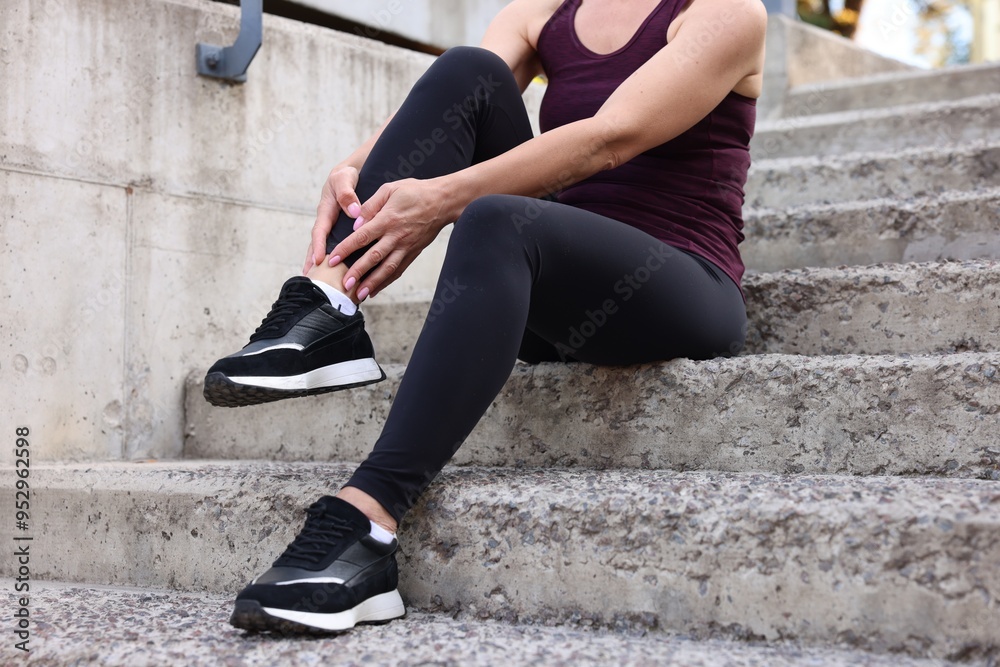 Woman suffering from foot pain on steps, closeup Woman suffering from foot pain on steps, closeup