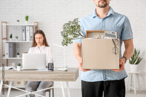 Fired young man with box of...
