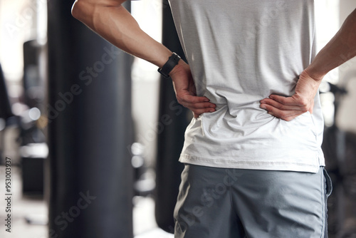 Back pain, man and fitness injury at gym for boxing, sport and training with accident at health center. Wellness, hands and exercise of an athlete with hurt lower hips and scoliosis concern of spine